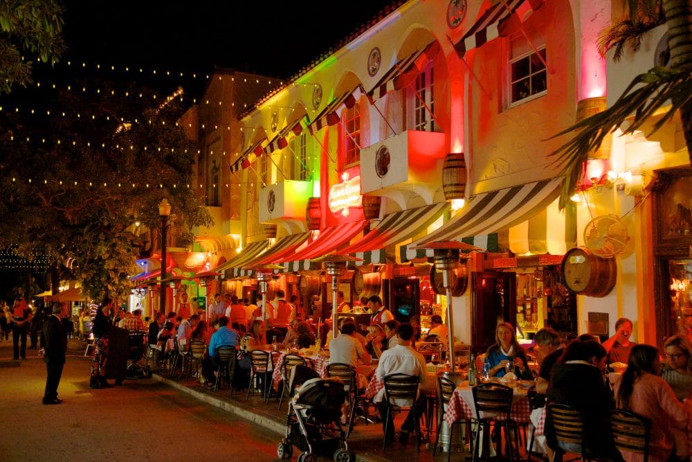 Dining al fresco at Espanola Way and Washington Avenue with colorful restaurants lit up at night in Miami Beach