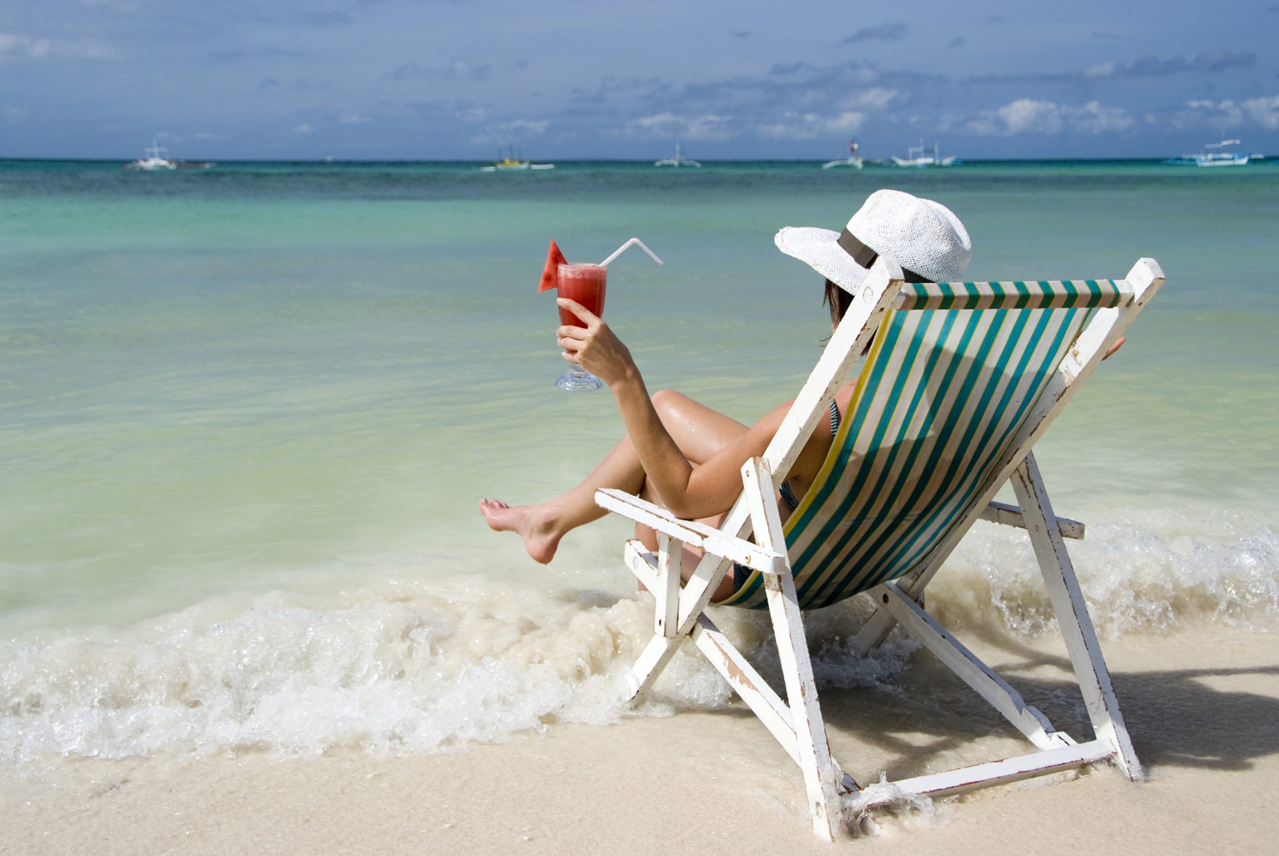 Woman with cocktail enjoys holidays at sea