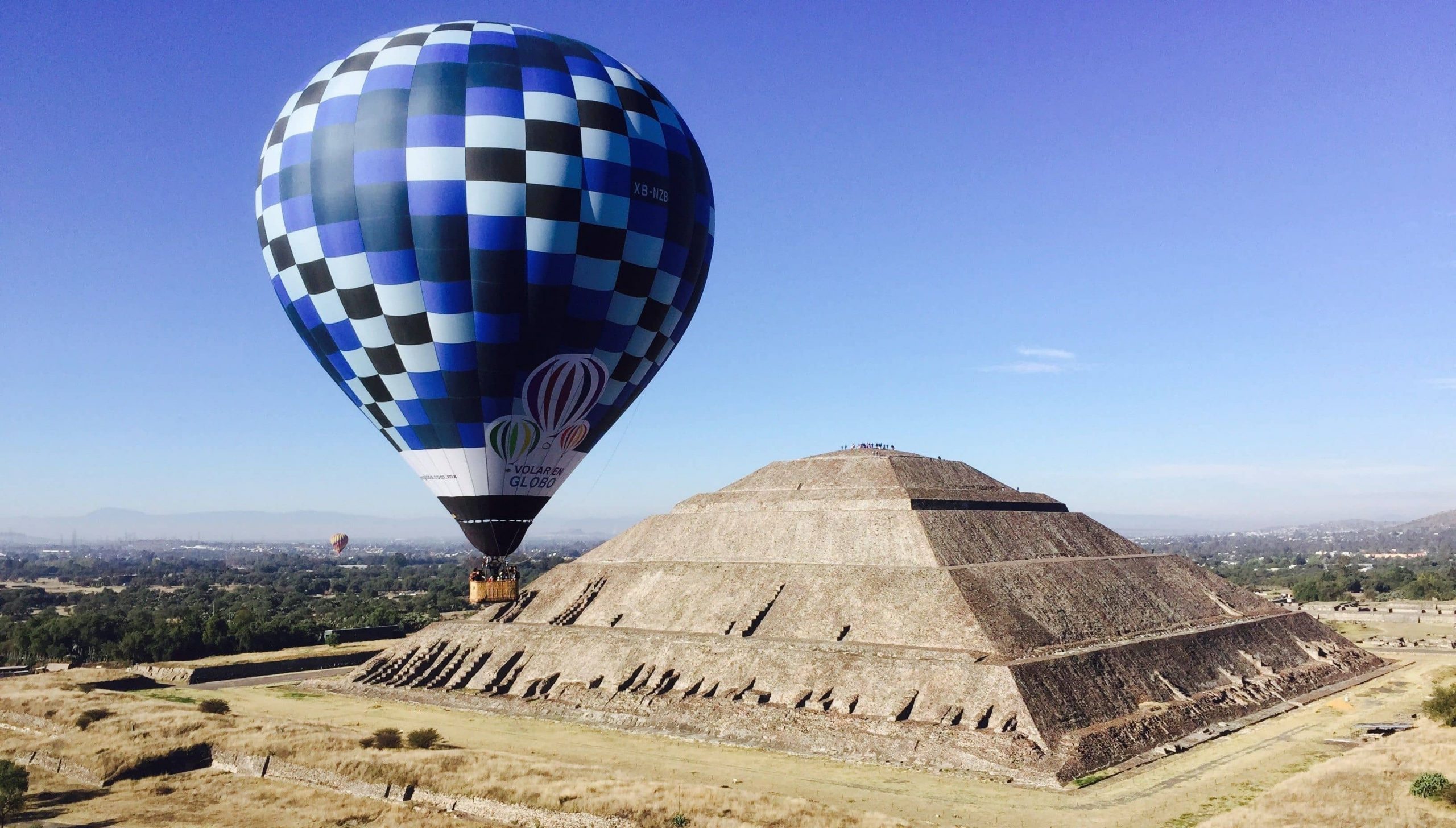Hot air balloon hovering over Teotihuacan ruins 