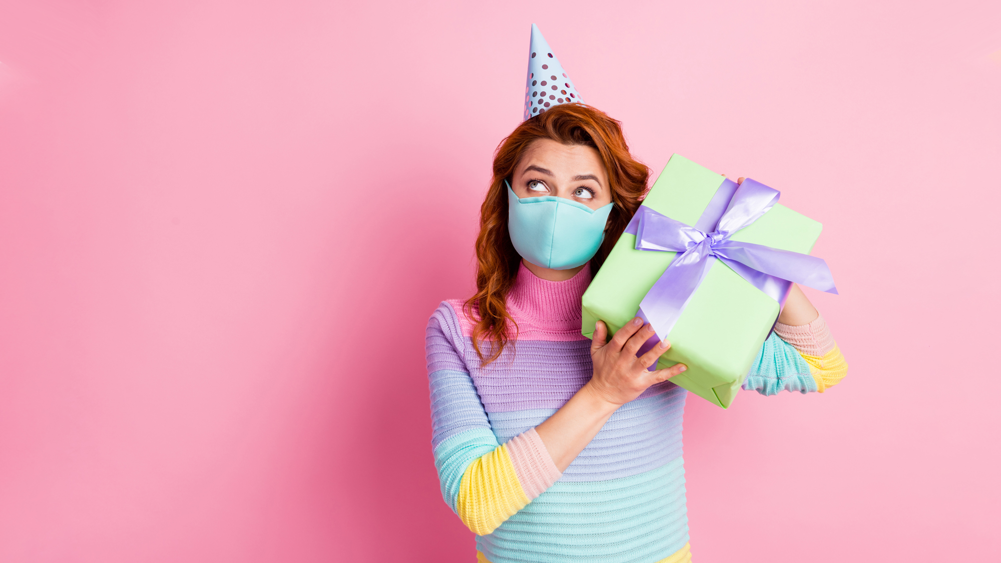 Woman wearing a mask and holding a birthday present