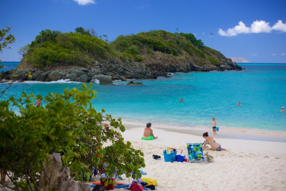 Barrier island seen off shore at Trunk Bay on St. John's Island with sunbathers and turquoise water