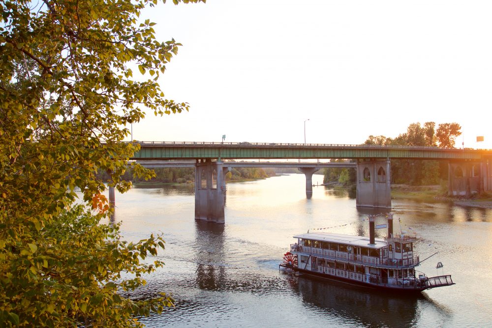 Sunset view of a boat going under the Union Street Railroad Bridge