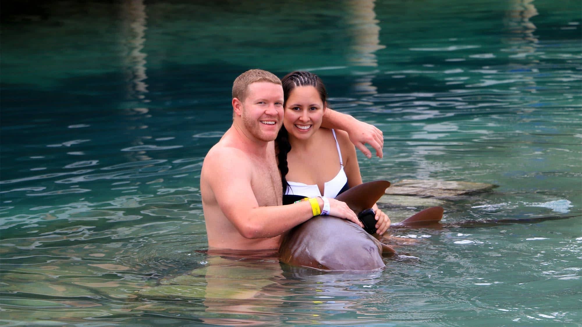 A couple posing with a tame nurse shark in Jamaica