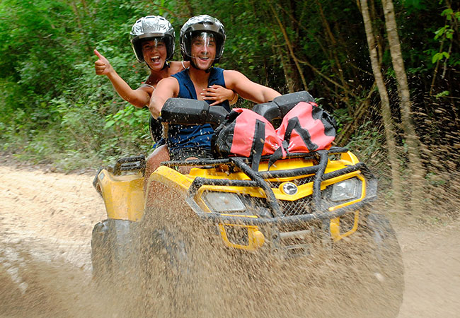 Couple rides through water on trail in jungle of Cancun