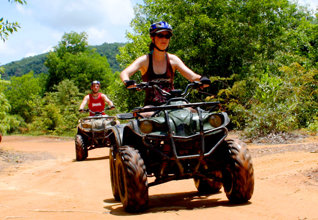 People riding ATVs in a Thailand Jungle