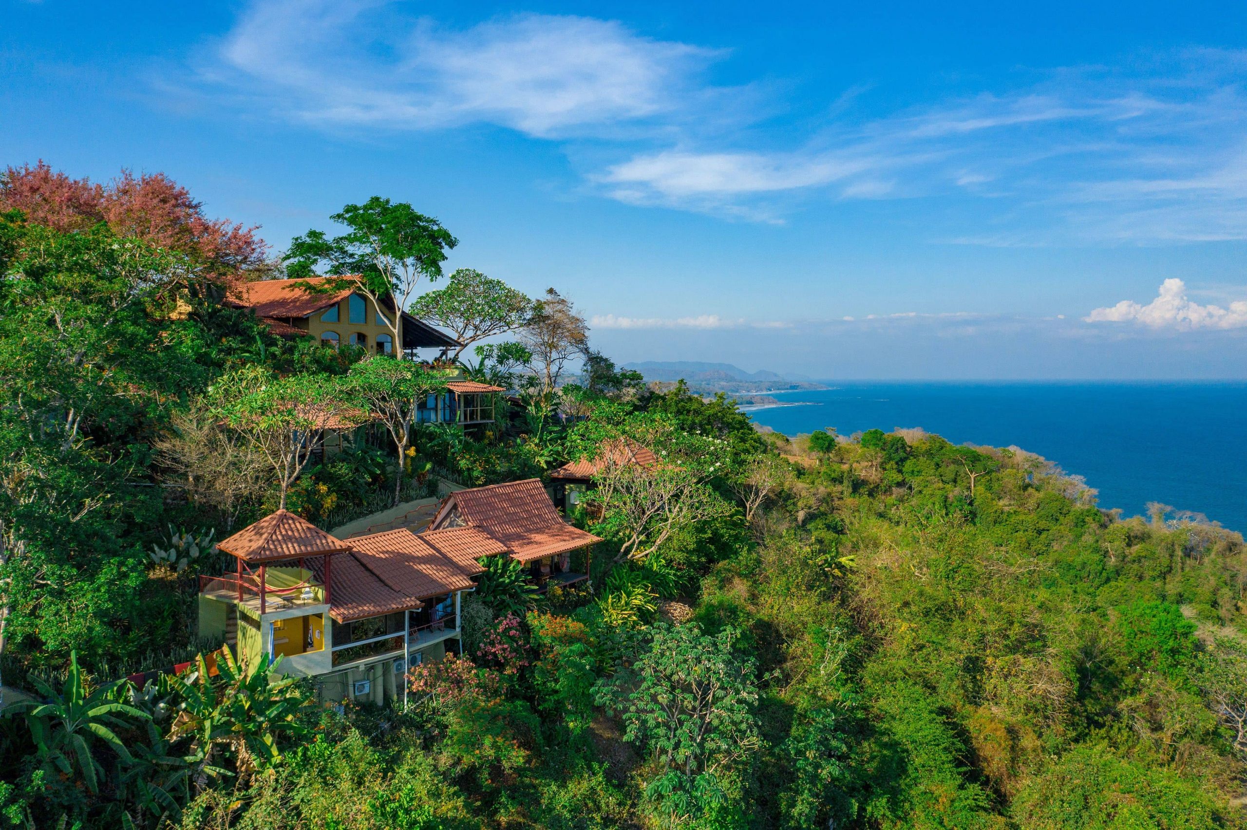 A beautiful birds eye view of the Anamaya Yoga Retreat resort properties amongst the Costa Rican jungle canopy and incredible bright blue seas.