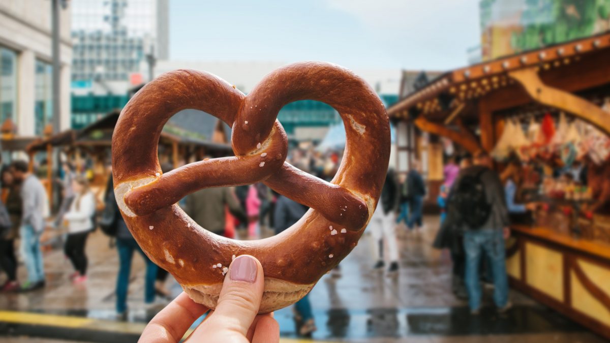Person holding a soft pretzel in a street market in Berlin, one of the worlds most vegan-friendly cities