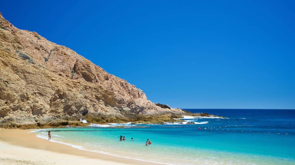 Blue water and rock cliffs at Santa Maria Beach in Los Cabos Mexico