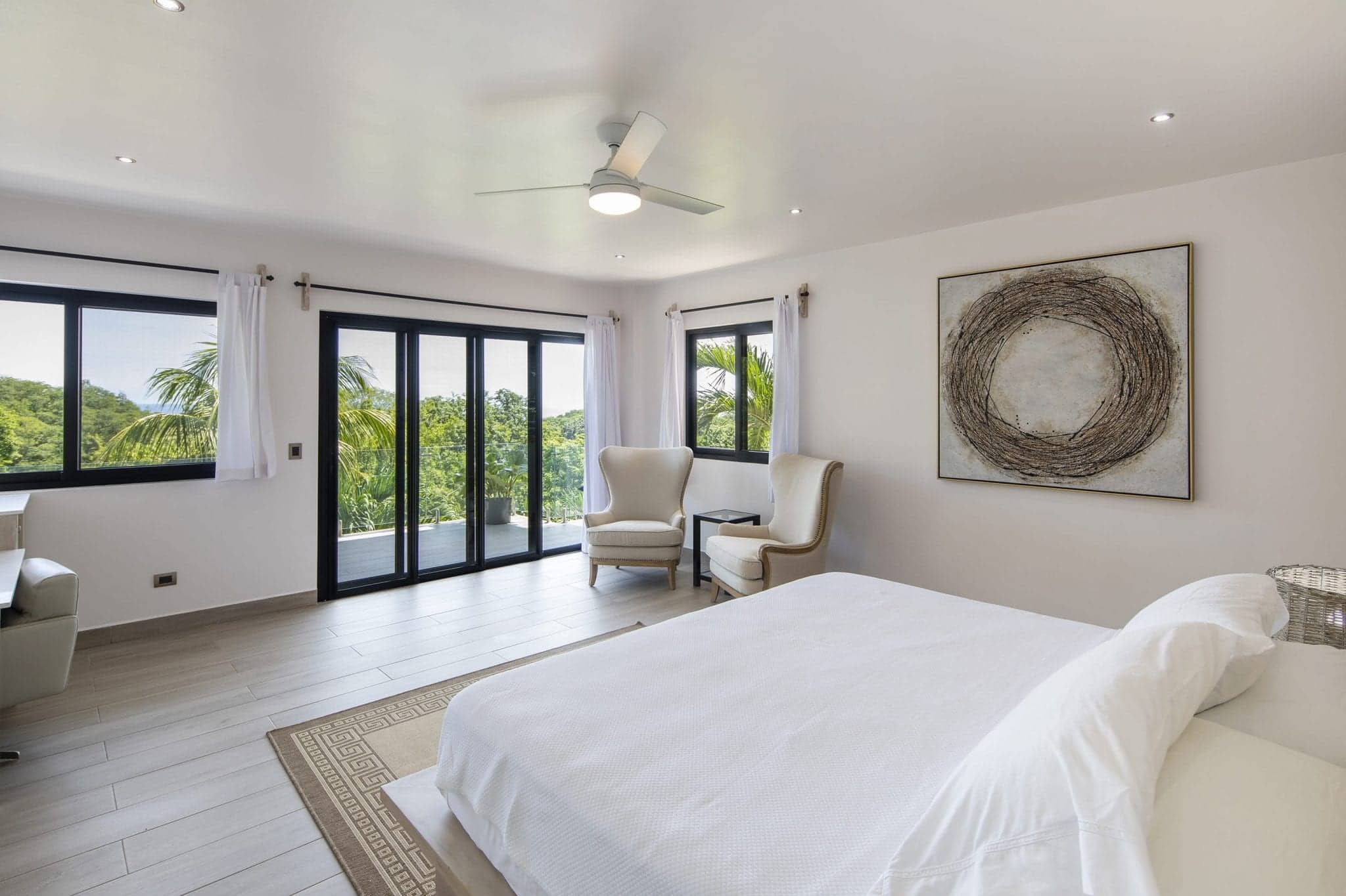 One of the guest rooms available at Bodhi Tree Yoga Resort in Costa Rica with beautiful white decor.