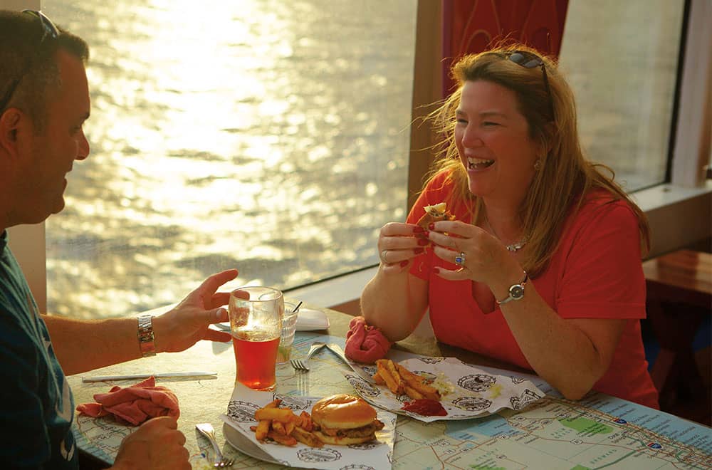 A cruise couple enjoying their meal at Guy's Burger Joint