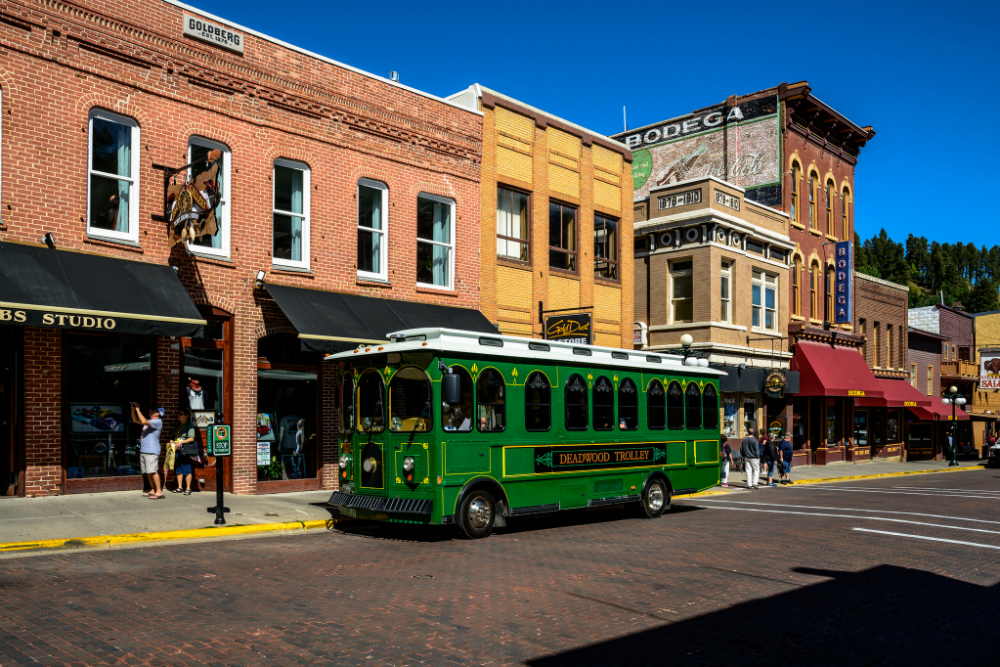 green trolley on the street in downtown Deadwood