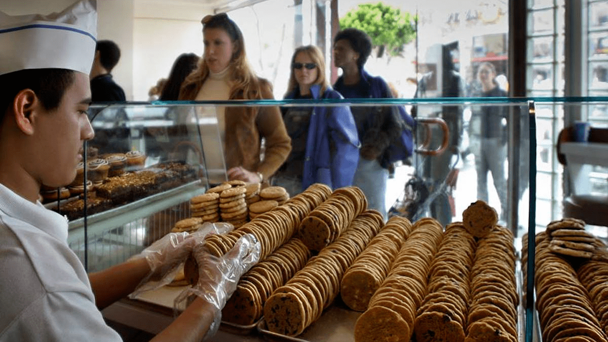 A staff member at Diddy Riese Cookies in Los Angeles, California choosing a selection of amazing cookies for a customer.