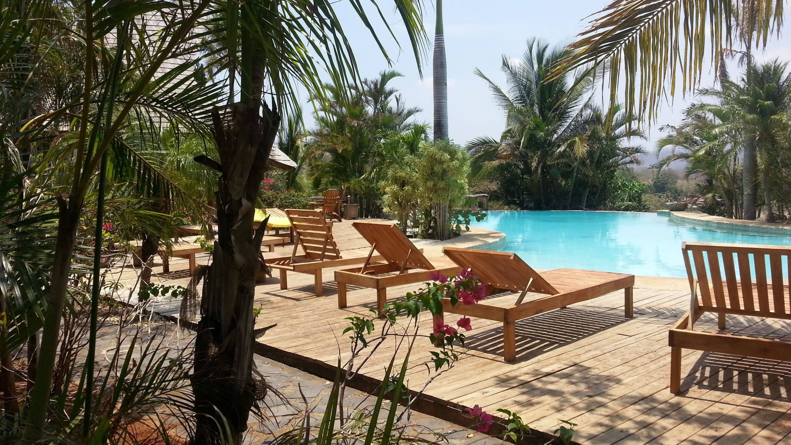A view of the pool with wooden deck sun loungers for guests of El-Sabanero Eco Lodge