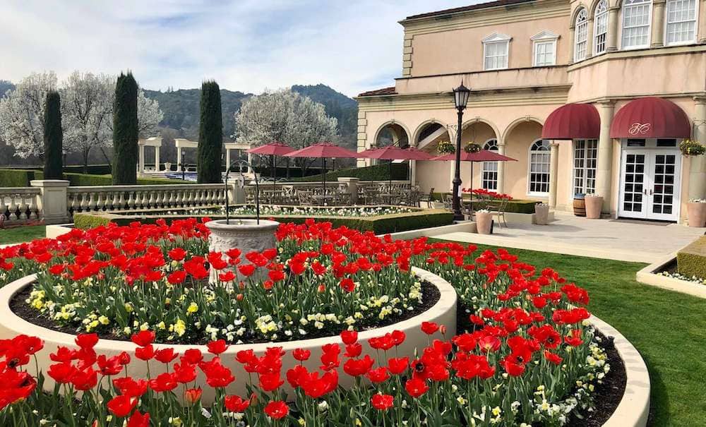 The building at Ferrari-Carano Winery near San Francisco, California with beautiful red flowers decorating the main entrance.