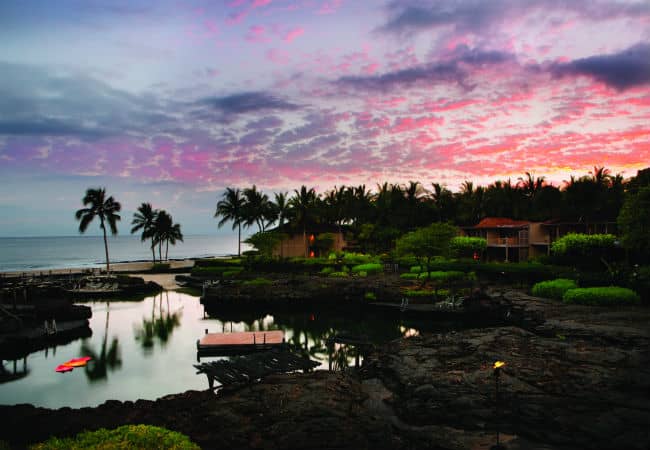 Lava rocks surrounding the beautiful King’s Pond aquarium pool at sunset.