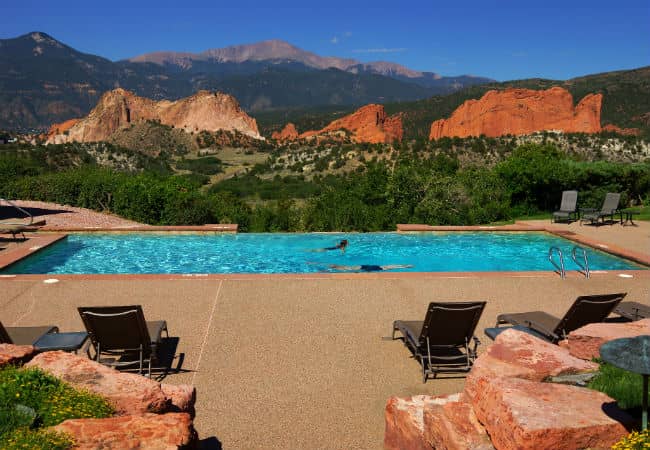Spa infinity pool that overlooks Pikes Peak with red rocks and a large pool deck at Garden of the Gods Club and Resort in Colorado Springs, Colorado.
