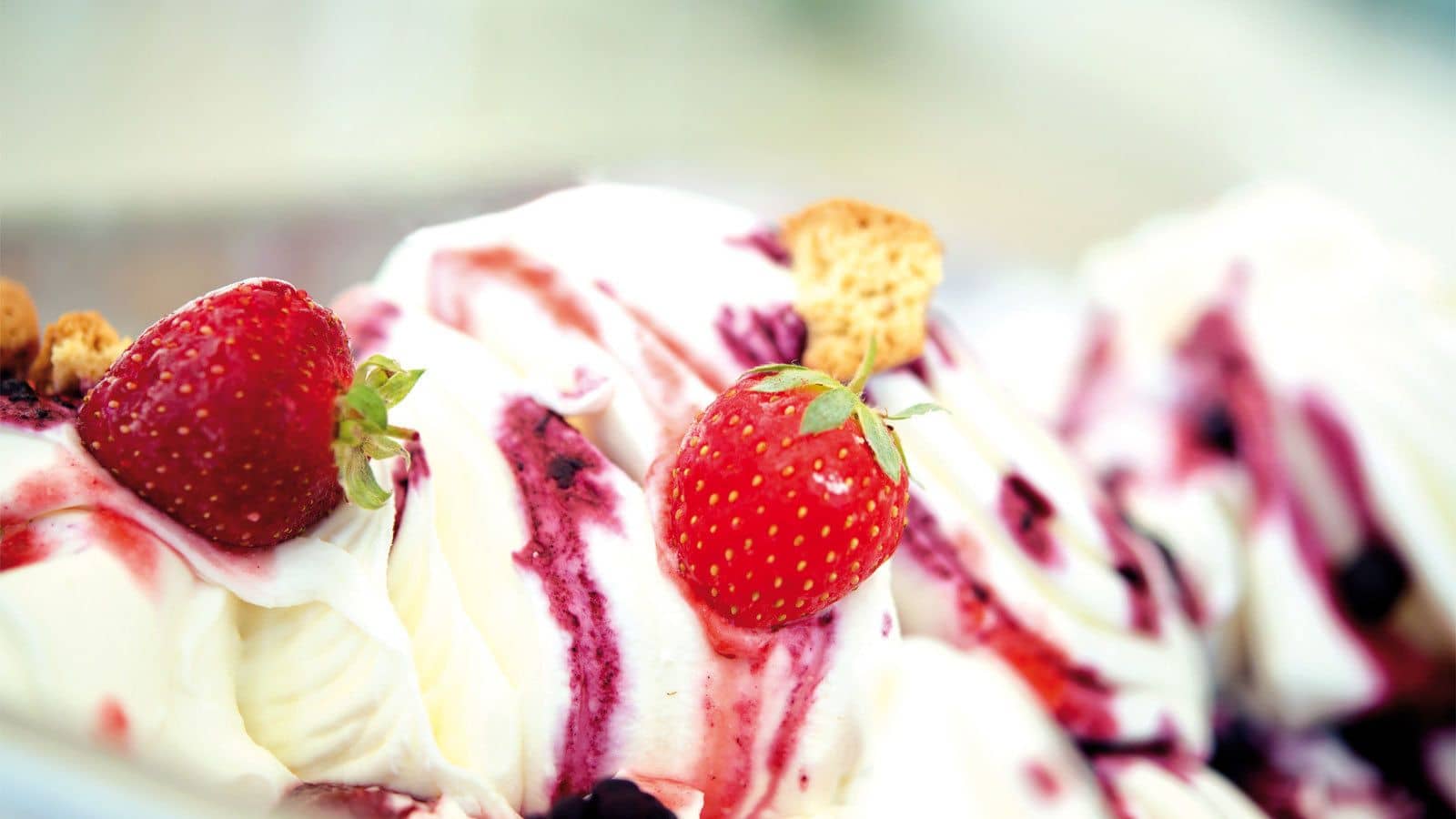 White gelato swirled and topped with strawberries