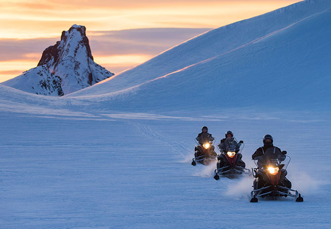 Group of snowmobiles traveling across glacier in Reykjavik