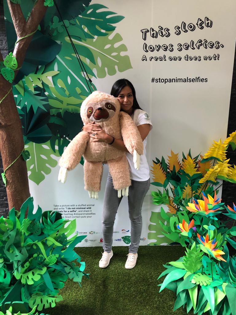 Woman hugging a sloth stuffed animal for #StopAnimalSelfies campaign 