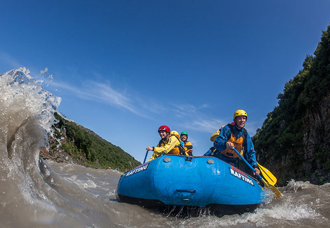 Rafters paddle down river rapids in Reykjavik