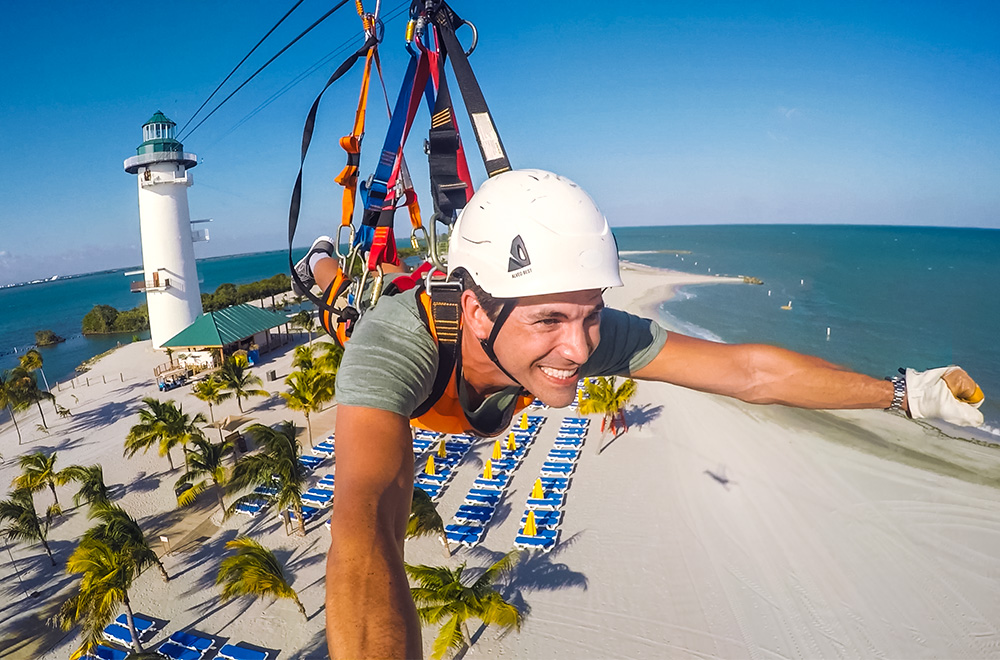 NCL-guest-doing-zipline-at-harvest-caye harvest-caye-private-island-ncl