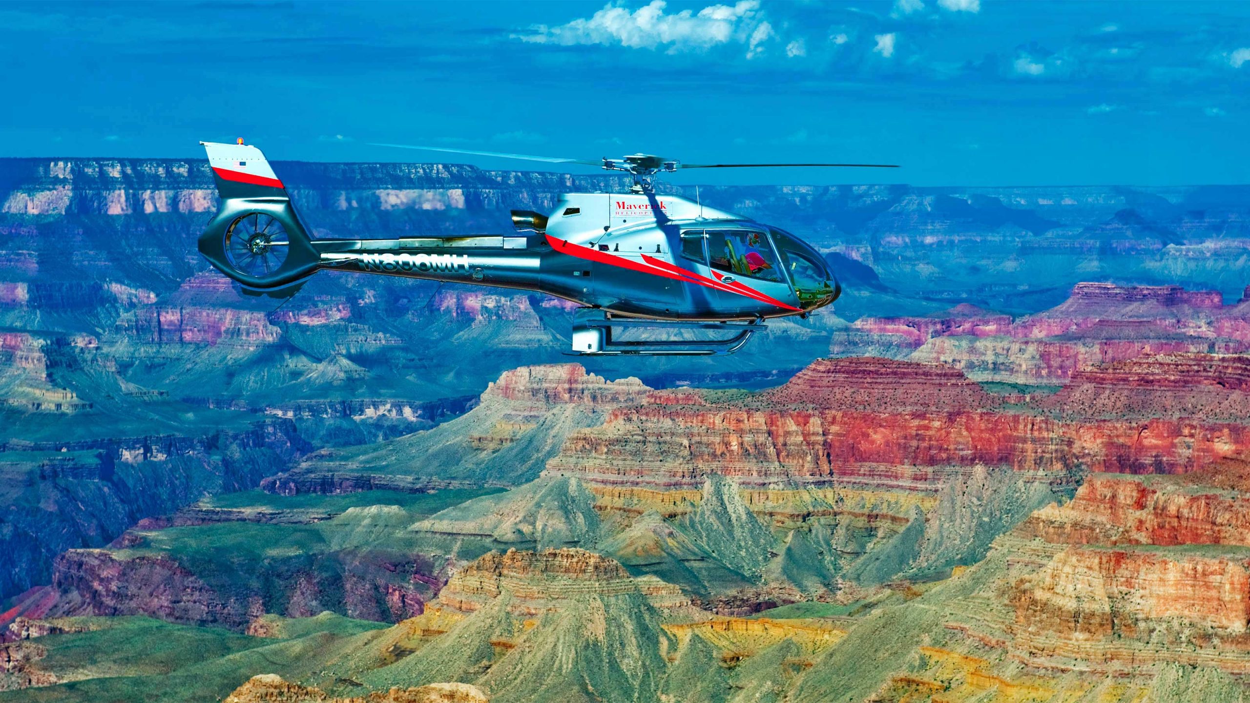 A helicopter hovers over the Grand Canyon.