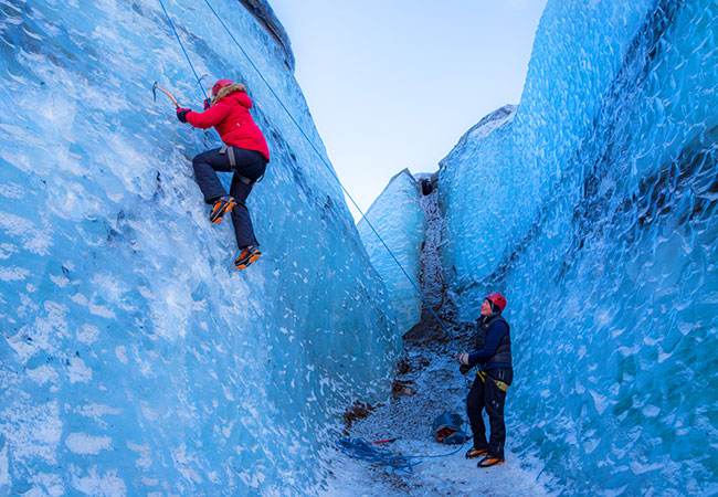 Climber scaling ice walls on glacier in Reykjavik