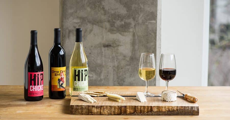 Bottles of wine on a wooden table and cheese board from the HIp Chicks Winery in Portland, Oregon. 