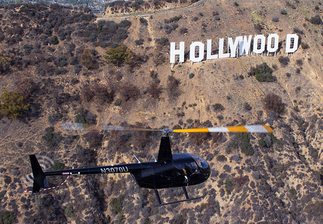Helicopter passing by Hollywood Sign in Los Angeles