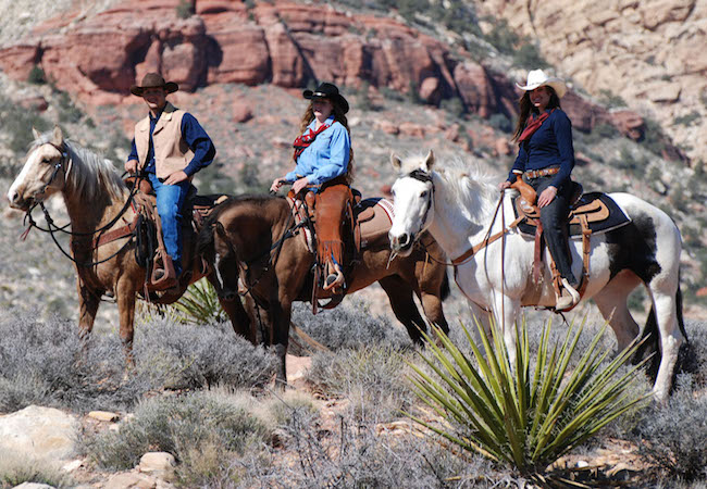 Three riders on horseback in Las Vegas desert