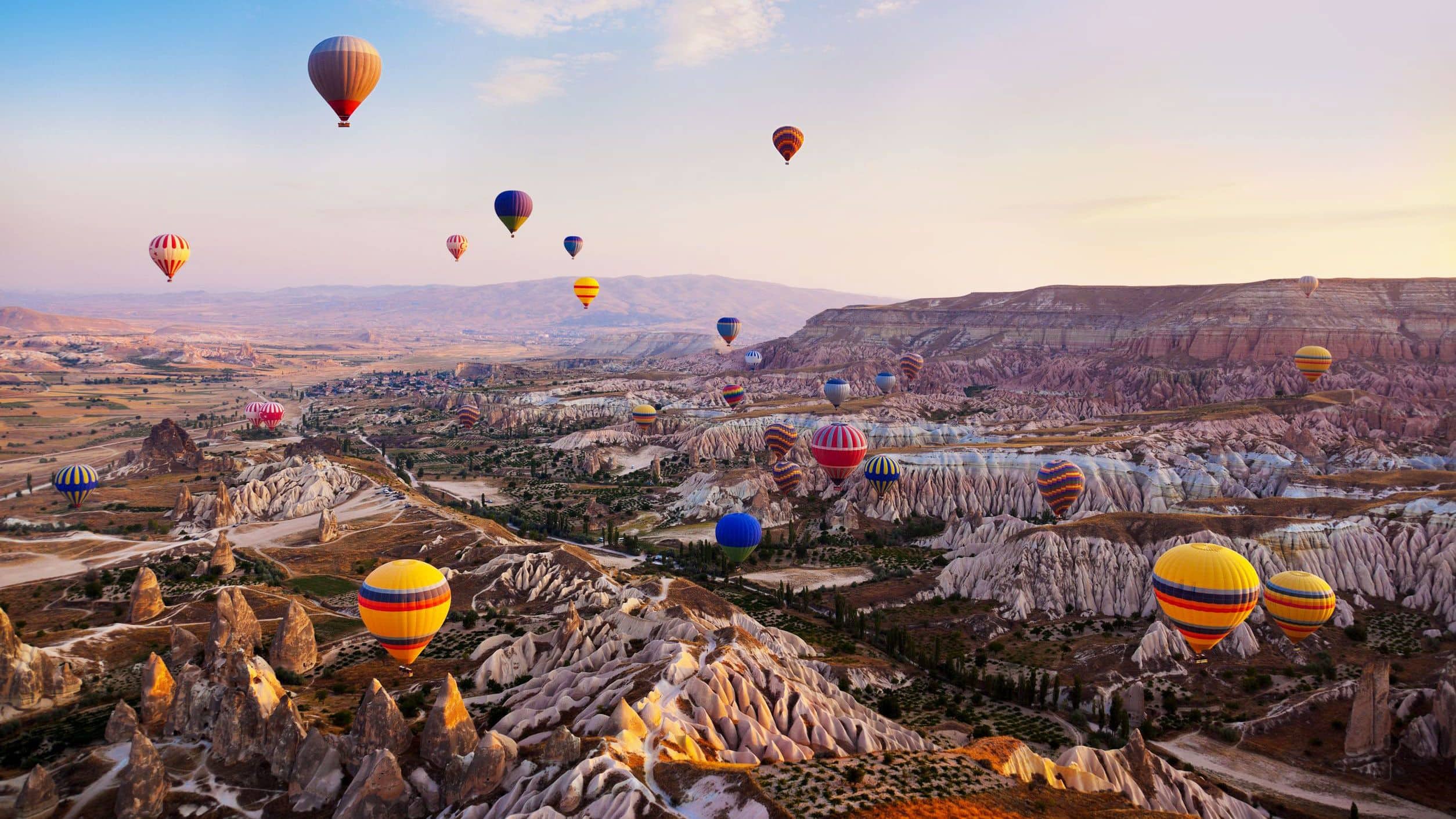 Hot air balloons flying over Cappadocia, Turkey at sunrise