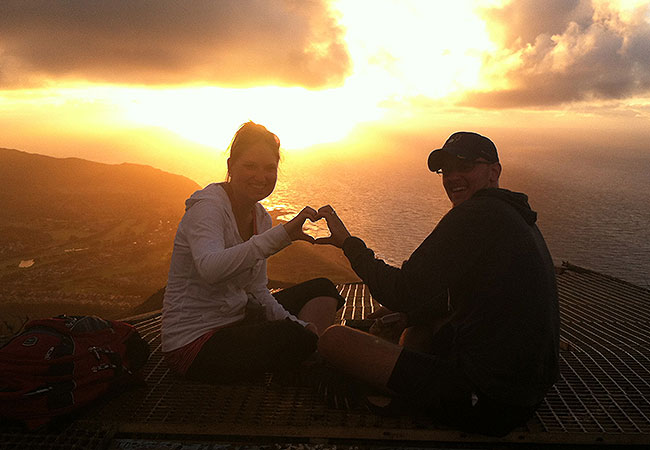 Couple enjoys sunrise on mountain peak in Honolulu