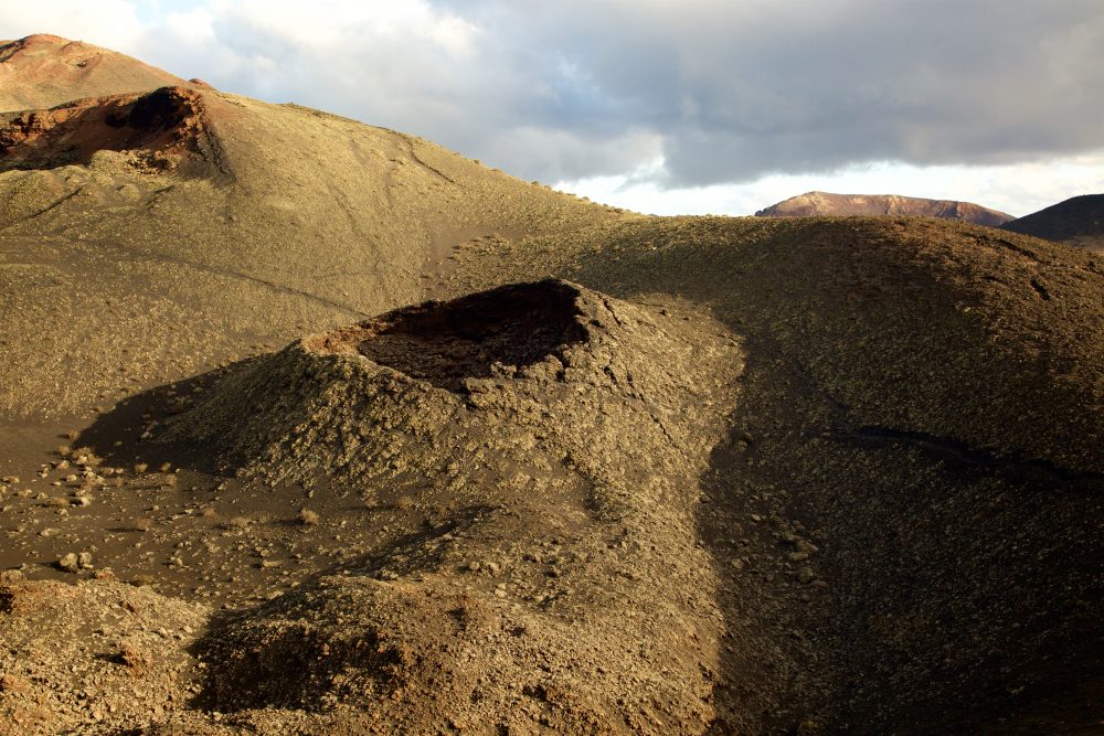 A crater pops out of the volcanic soil of Timanfaya National Park on Lanzarote Island