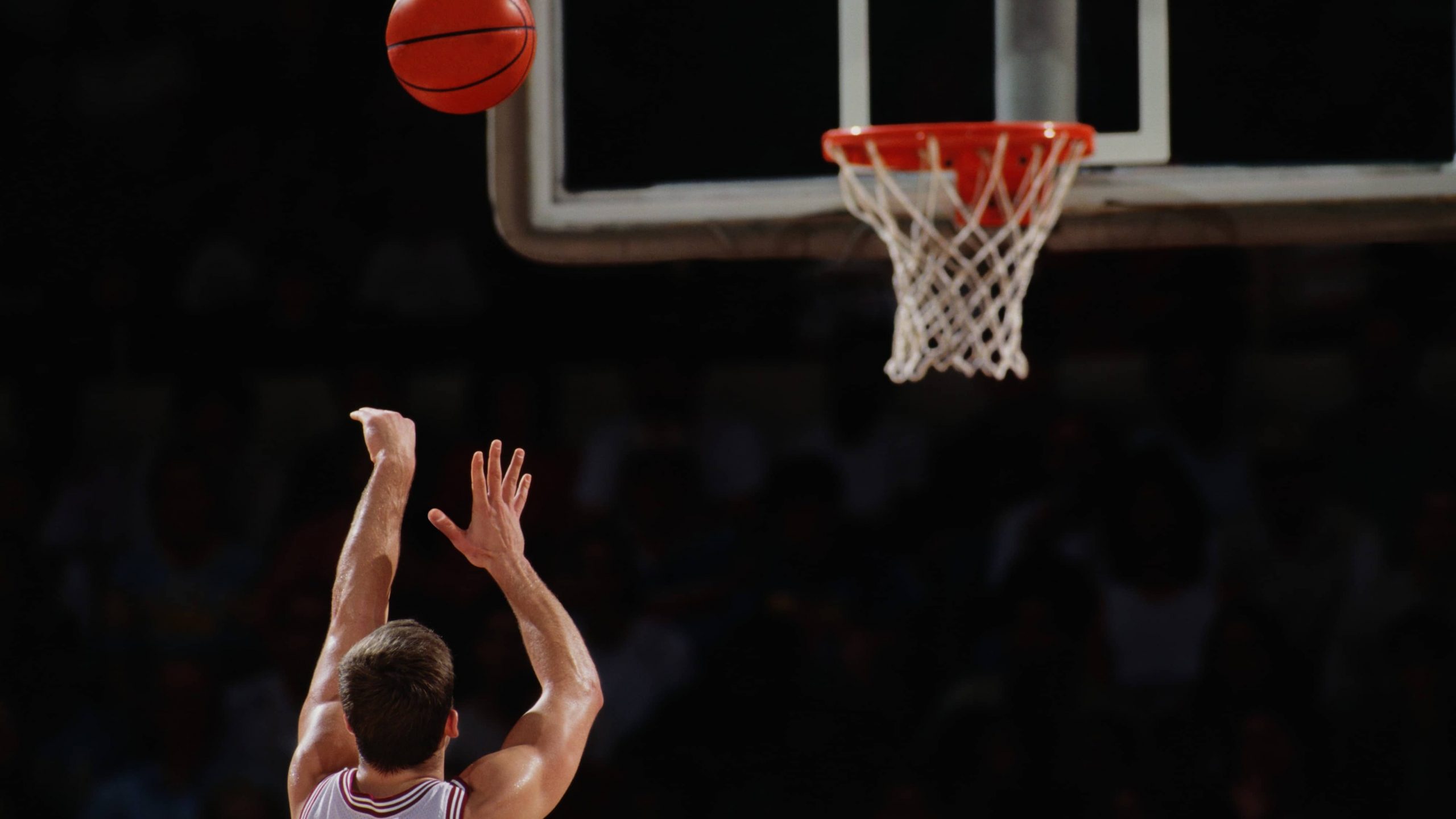 College basketball player taking a shot at the hoop