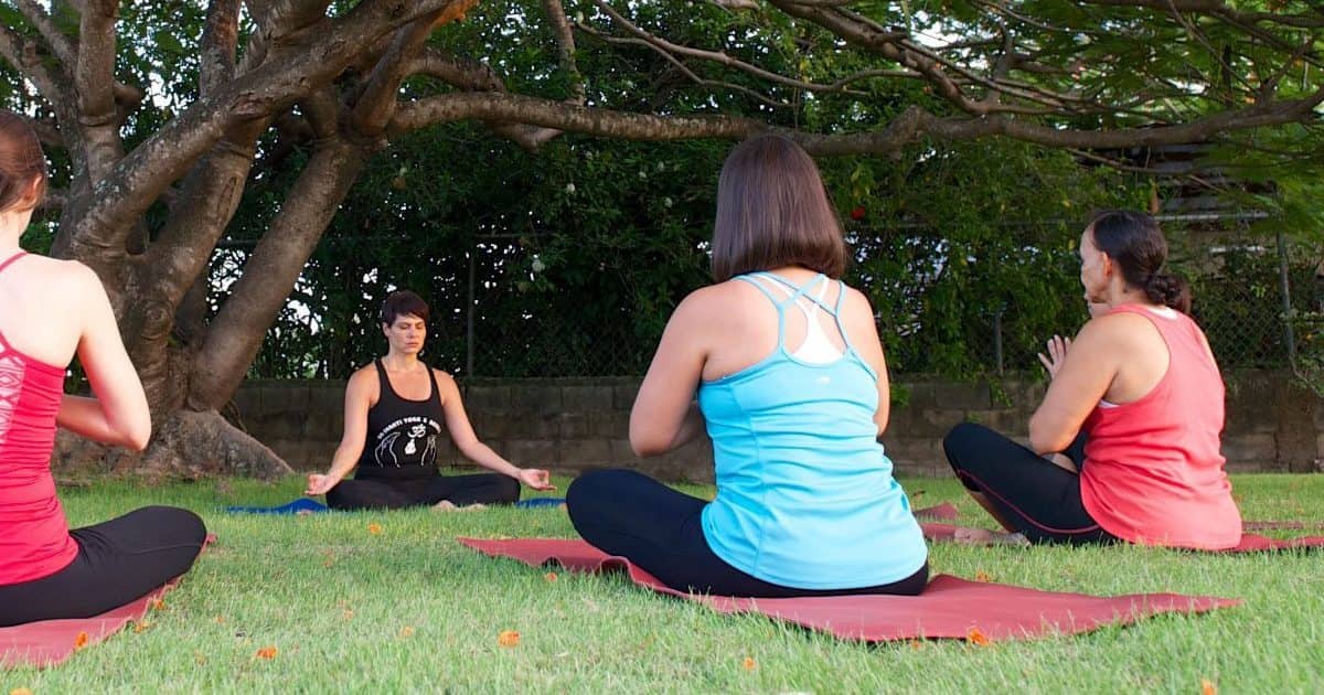 A group of women sitting outdoors in Belize at a Yoga Retreat