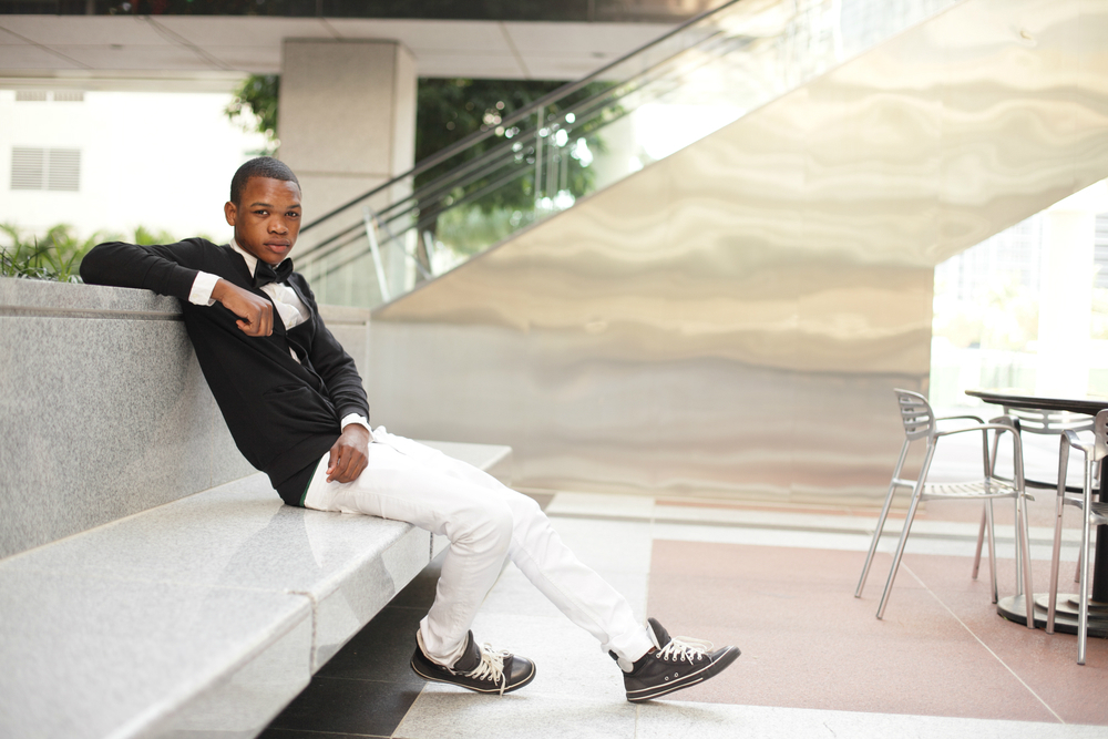 stylish man sitting on marble bench in courtyard