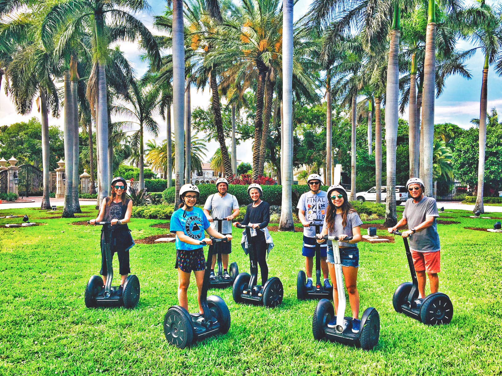 Segway riders pose on Miami's lush grass.