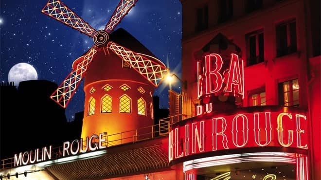 The famous windmill and neon sign outside the Moulin Rouge in Paris, France.