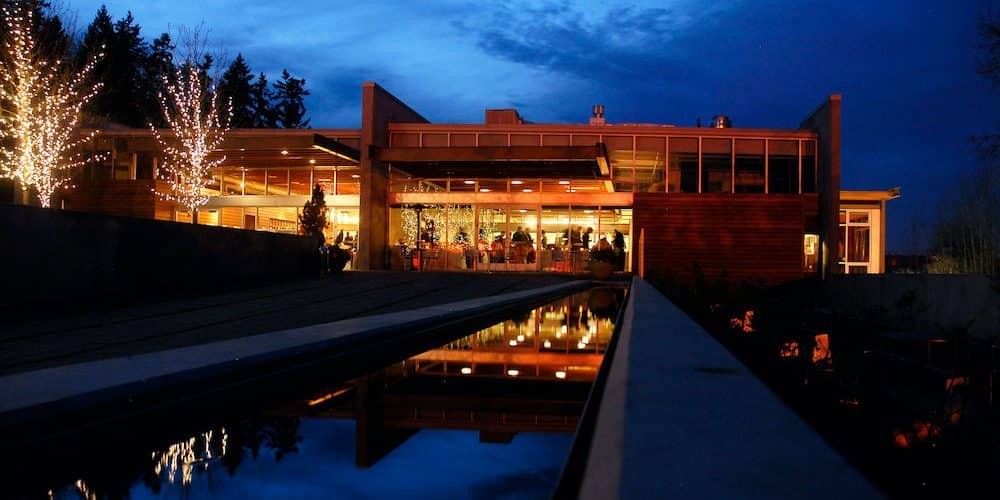 The Novelty Hill Januik Winery in Seattle, Washington at dusk with warm lights accenting the beautiful wine-tasting building. 