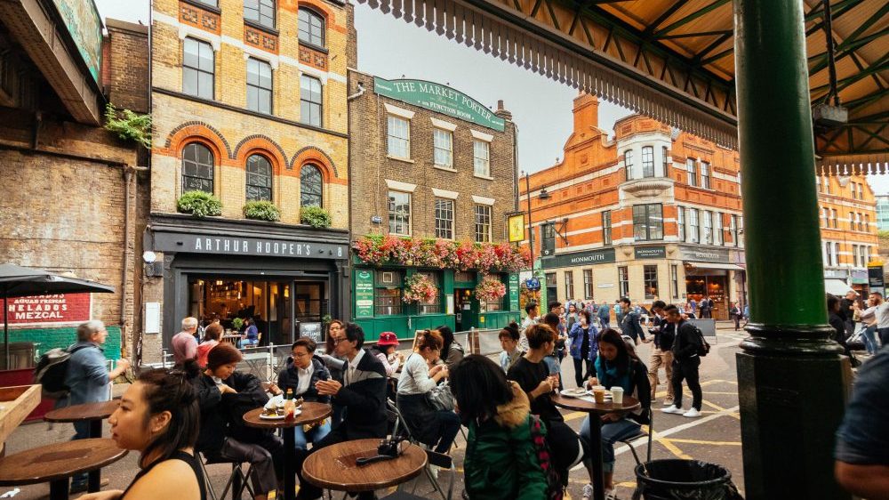 People enjoying outdoor seating at a cafe in the vegan-friendly city of London