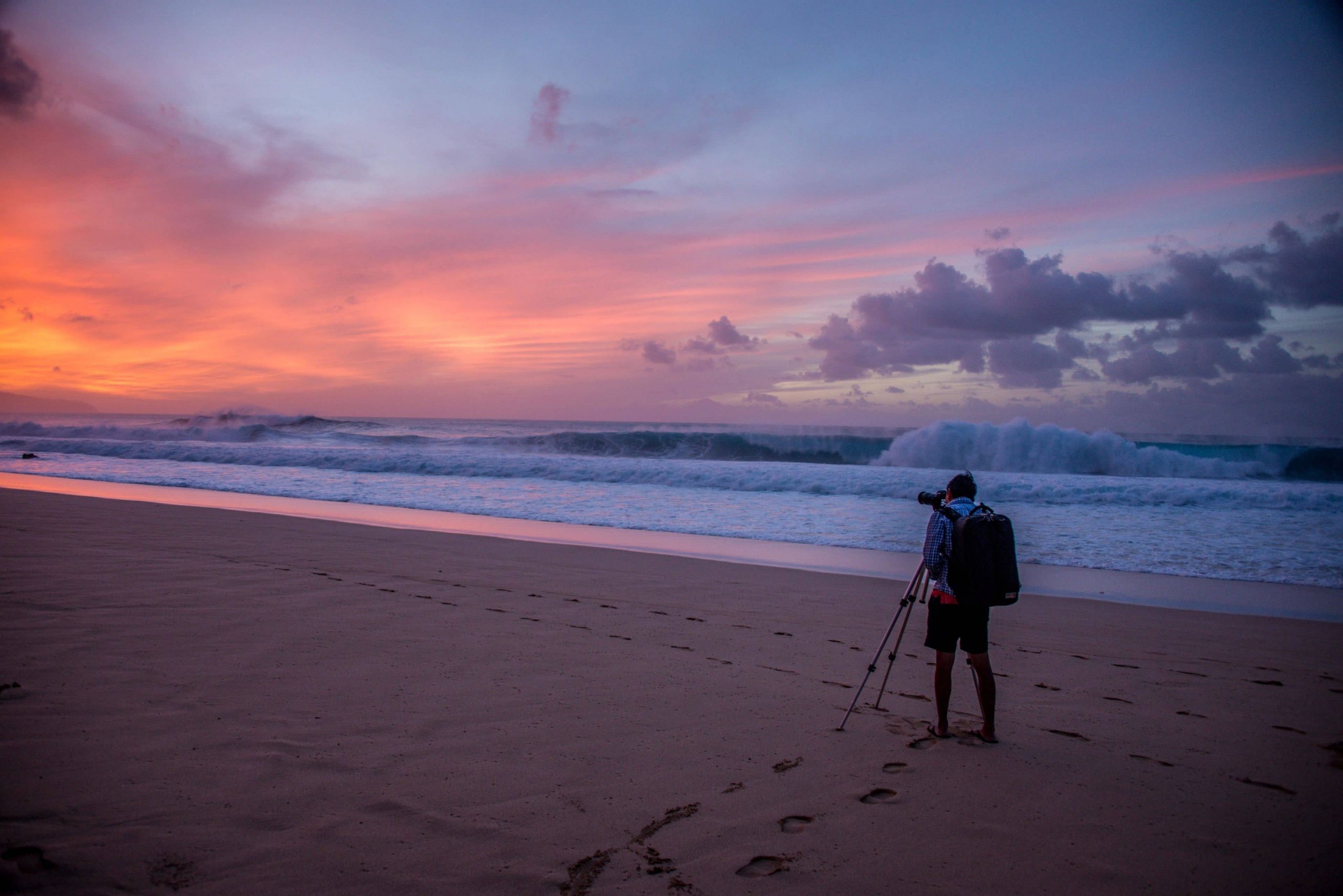 Person photographing the sunset on the beach in Oahu