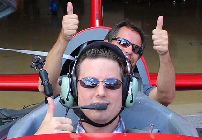 Two smiling men with thumbs up sign inside the airplane at Sky Combat Ace in Las Vegas