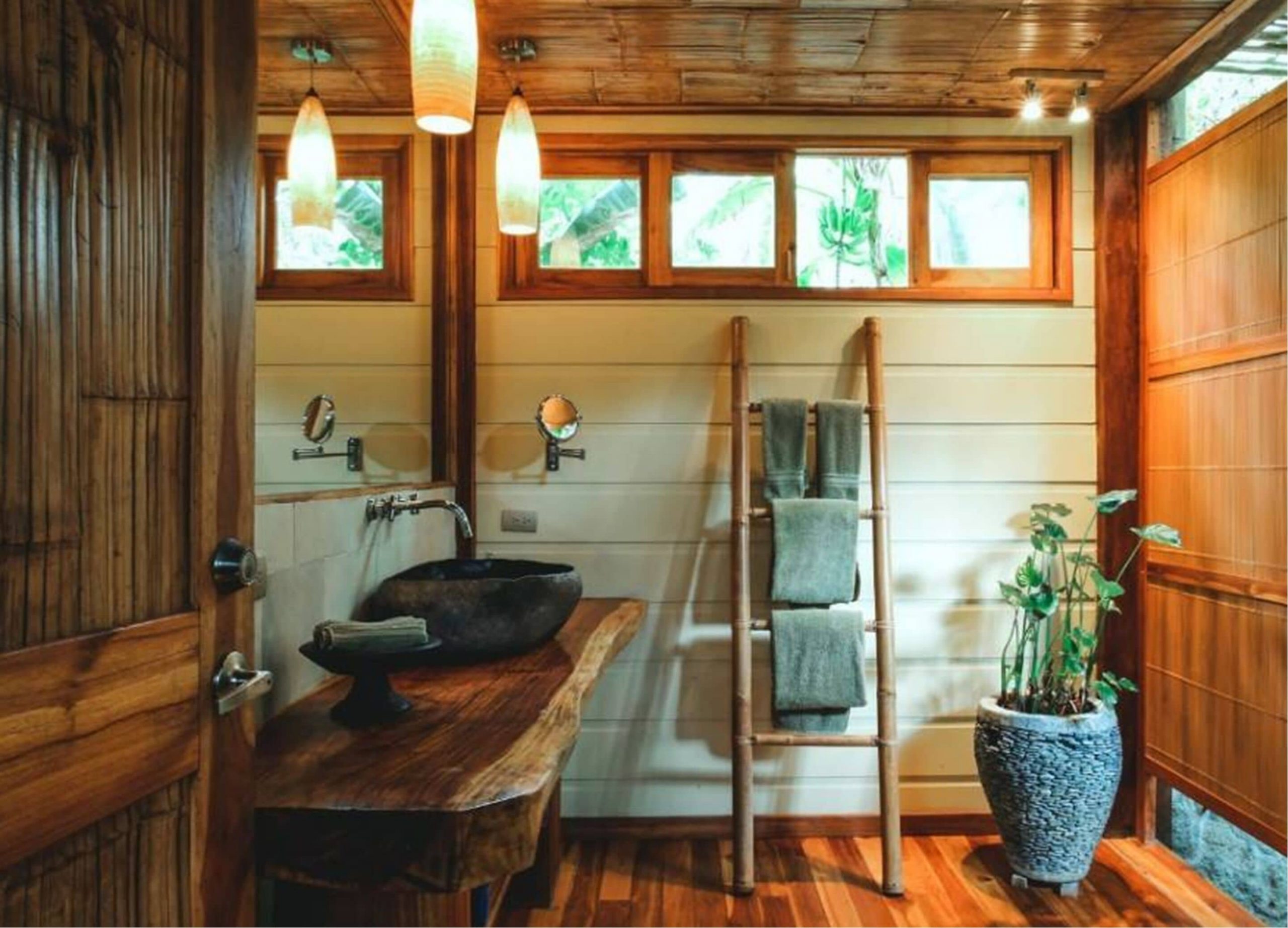 Inside the Pranamar Villas and Yoga Retreat for guests with beautiful wooden interior decor, ladder, and luxury bathroom amenities.