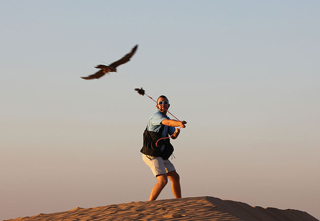 Man lures in falcon during falconry experience in Dubai