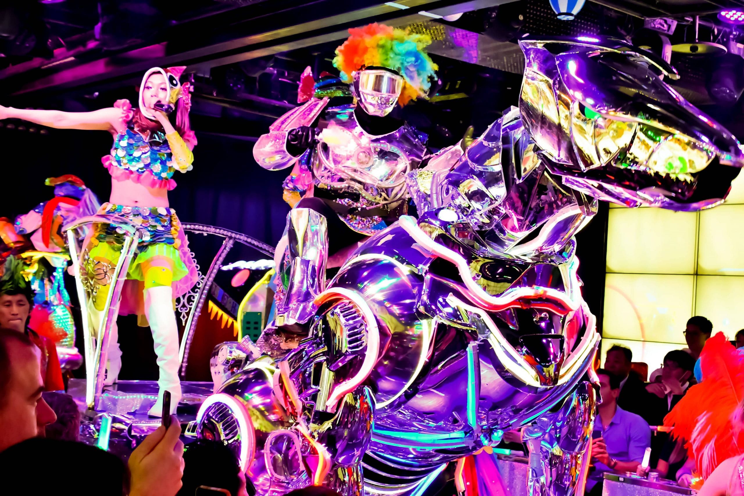 Rainbow-haired robot riding a chrome dinosaur at the Robot Restaurant Show in Tokyo