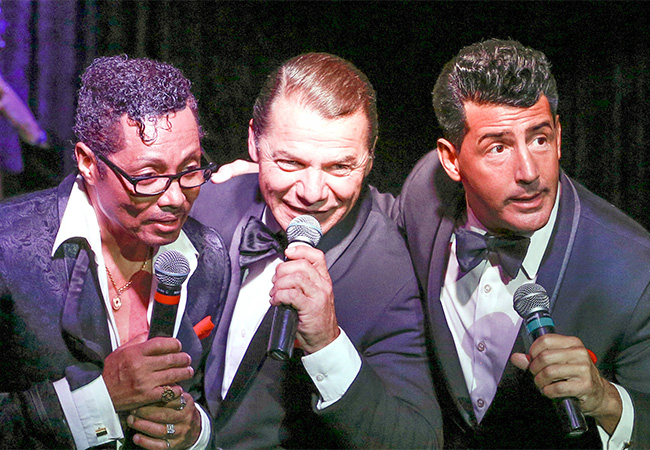 Rat Pack impersonators singing onstage in Las Vegas