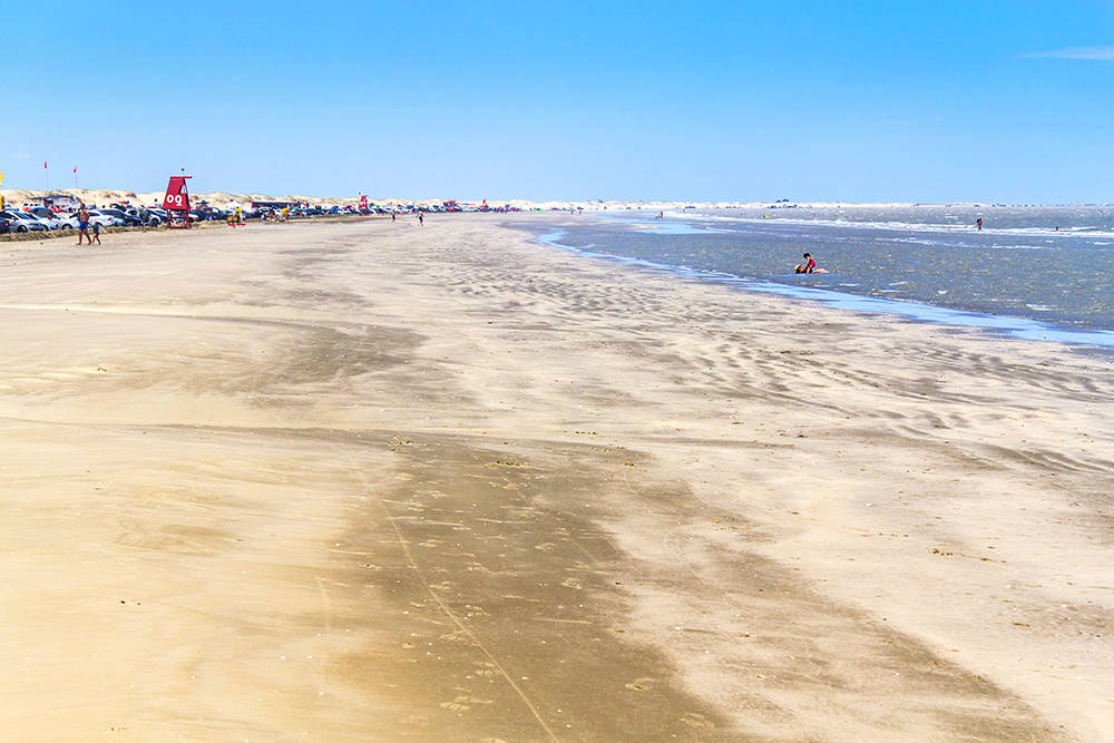 Long stretch of sand and ocean as far as the eye can see at Praia do Cassino Beach in Rio Grande do Sul. 