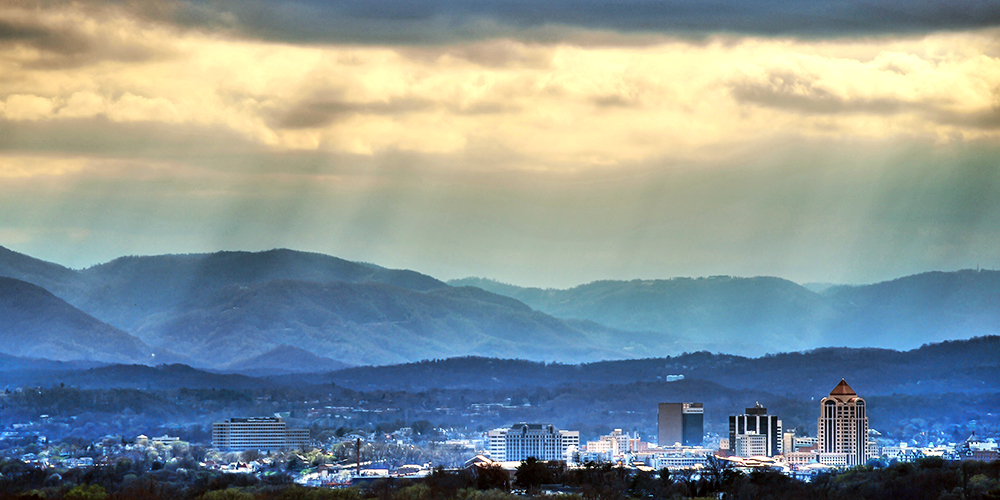 Sun shining down on Roanoke with the Blue Ridge mountains in the distance.