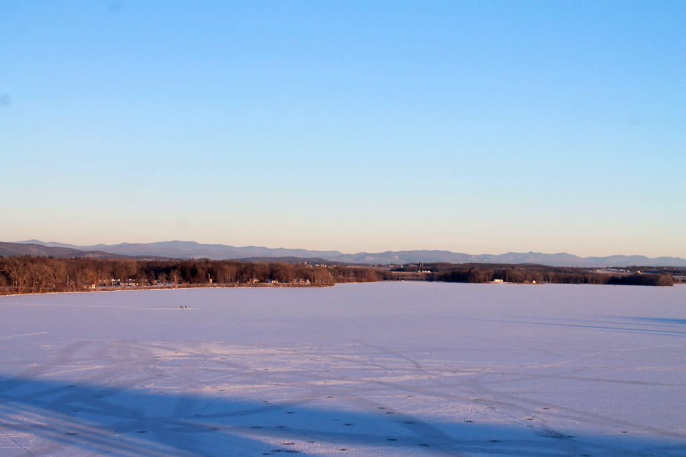 Snow-covered landscape, surrounded by brown trees and mountains in the distance, in Westport.