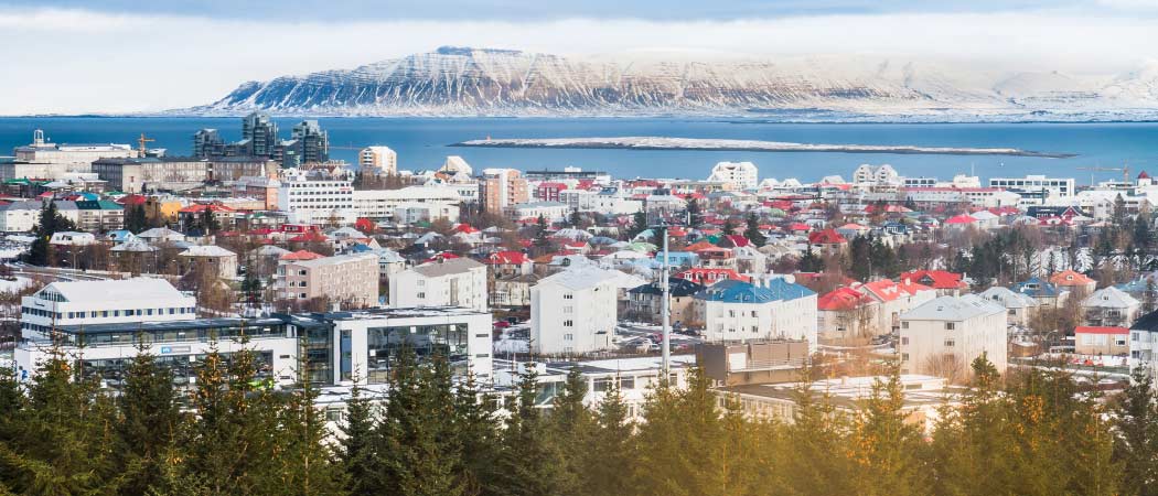 Aerial view of Reykjavik showing snowy mountains, a city and a coastal town